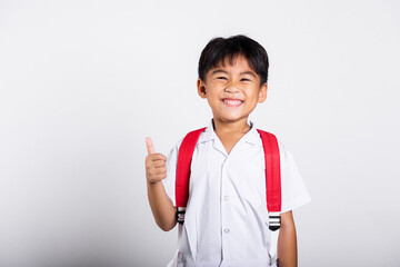 Asian adorable toddler smiling happy wearing student thai uniform red pants show thumb up finger in studio shot isolated on white background, Portrait little children boy preschool, Kid Back to school