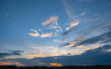 Wall Mural - Colorful sunset and sunrise with clouds. Blue and orange color of nature. Many white clouds in the blue sky. The weather is clear today. sunset in the clouds. The sky is twilight.