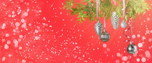 Beautiful Christmas Baubles Hanging On Coniferous Branch Against Red Background