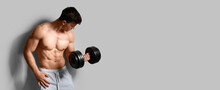Muscular Bodybuilder With Dumbbell On Light Background With Space For Text