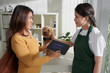 © DragonImages - Happy client rating service of animal clinic via application on tablet computer