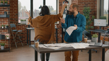 Wall Mural - workmates arguing and fighting about business project, trying to work on papers with rate charts. ag