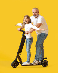 Wall Mural - Little girl with her grandfather and electric scooter on yellow background