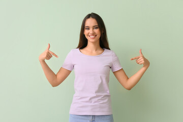 Wall Mural - Pretty young woman in stylish t-shirt on green background
