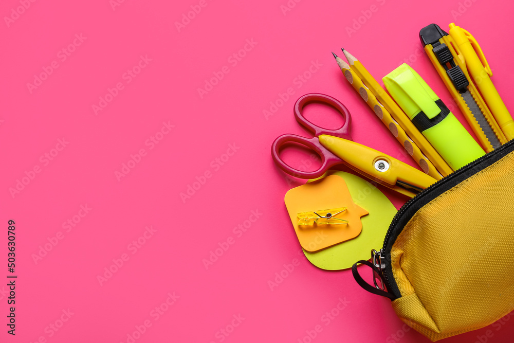 Yellow pencil case with stationery supplies on pink background