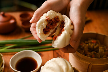 Chinese dim sum cuisine, Female hands holding a steamed pork bun