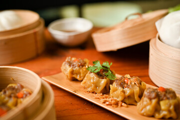 Wall Mural - Delicious steamed shrimp or pork dumplings on a wooden plate