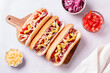 Homemade hotdogs with sausage. onion, tomato and cheese on light gray background