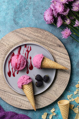 Wall Mural - Vertical  top view of a berry ice cream with topping designed with flowers on a blue surface