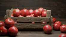 Pomegranates, Juicy Fruits In A Crate On Wooden Floor
