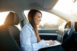 © verona_studio - Beautiful young business woman using laptop and phone in the car