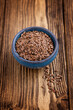 Blue bowl with dark flax seeds on a white background
