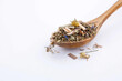 Wooden spoon with dry herbal tea on a white isolated background.