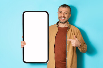 Poster - Man Showing Large Smartphone Advertising Application Over Blue Background, Mockup