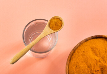 Poster - Spoon with organic turmeric and glass of filtered water - Curcuma longa