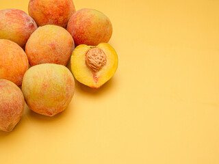 Wall Mural - Pile of fresh peaches fruit over a yellow background