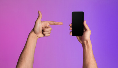 Poster - Closeup of young guy pointing at smartphone with empty black screen, showing space for new mobile app or website