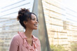 © Wavebreak Media - Smiling african american mid adult businesswoman looking away while standing in office balcony