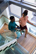 © Wavebreak Media - Smiling african american mid adult business professionals talking while climbing steps in office