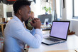 © Wavebreak Media - African american mid adult businessman with hands clasped looking at laptop with blank screen