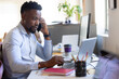 © Wavebreak Media - African american mid adult businessman talking on phone while using laptop at desk in office