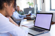 © Wavebreak Media - African american mid adult businesswoman using laptop with blank screen while working in office