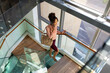 © Wavebreak Media - African american mid adult businesswoman with purse talking on phone while climbing steps in office