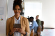 © Wavebreak Media - Portrait of smiling african american mid adult businesswoman with digital tablet standing in office