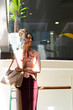 © Wavebreak Media - Smiling african american mid adult businesswoman talking on smart phone while standing in office