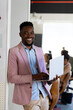 © Wavebreak Media - Portrait of smiling african american mid adult businessman with laptop standing in office