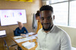 © Wavebreak Media - Portrait of smiling african american mid adult businessman with colleagues working in background