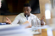 © Wavebreak Media - African american mid adult businessman gesturing while sitting at desk during meeting in office