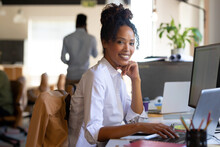 Portrait Of African American Mid Adult Businesswoman Using Laptop While Sitting With Hand On Chin