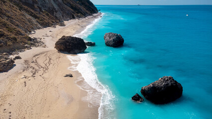 Aerial view of beautiful sandy beach and soft turquoise ocean wave. Tropical sea in summer season on Megali Petra beach on Lefkada island.