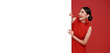 Happy asian woman in red casual attire with blank announcement banner in red background.