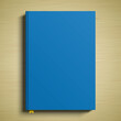 Blue book cover 3D vector mockup. A closed paperback book lying on a wooden table surface.