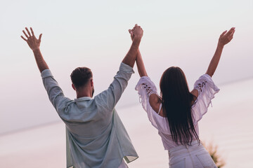 Poster - Photo of cute excited boyfriend girlfriend dressed casual outfit celebrating rising arms outdoors countryside