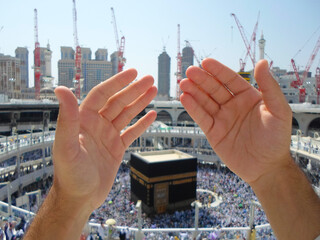 Muslims raise their hands to pray at the Kaaba