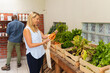 © Wavebreak Media - Caucasian mid adult woman buying vegetables and african american man purchasing groceries in store