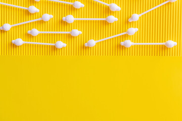 Wall Mural - top view of hygienic cotton swabs on textured and yellow background with copy space.