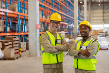 Smiling Asian Mature Male Worker And African American Young Man With Arms Crossed Wearing Vests