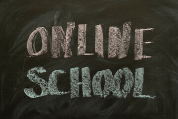 Inscription Online School on a black board with chalk. Words ONLINE SCHOOL written in chalk on a blackboard. Distance education concept. 