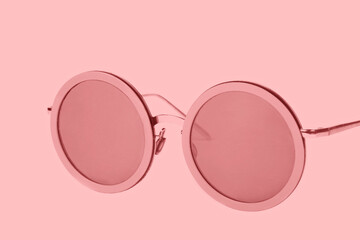 Pink sunglasses on a pink background.