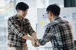 © Wasan - Handshake. Young men shaking hands with colleagues in the office.
