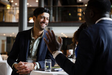 Happy Businessman Leaning On Table While Talking With Entrepreneur At Seminar