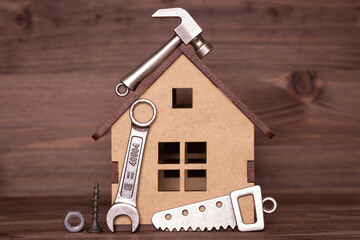 Wooden house model with hand tools and fasteners