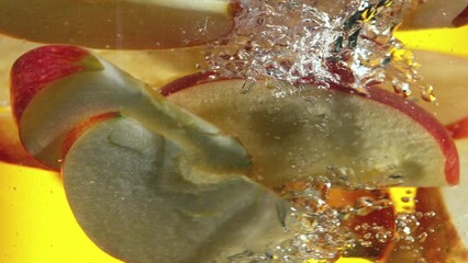 Fototapete - Super slow motion of rotating sliced apples pieces underwater. Filmed on high speed cinema camera, 1000 fps.