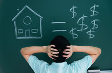 Man In Front Of Drawing House And Money On Blackboard