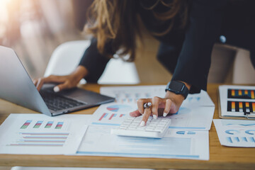 Poster - Close-up of business woman hand using a calculator to check company finances and earnings and budget.