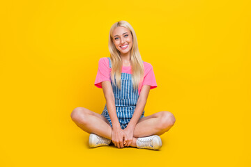 Poster - Full size photo of lovely satisfied girl sit floor crossed legs toothy smile isolated on yellow color background